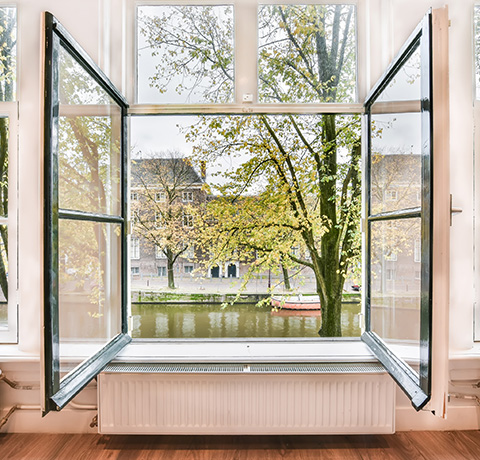 open window showing trees and a canal view with autumn leaves and a serene atmosphere for a 15 minute escape