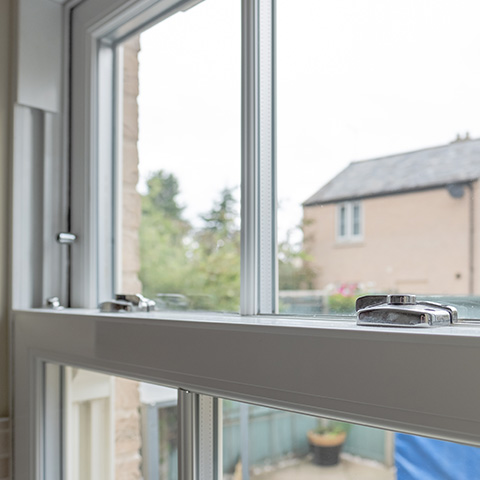 interior view of window with locking mechanism showing trees and buildings outside six features of this modern window design